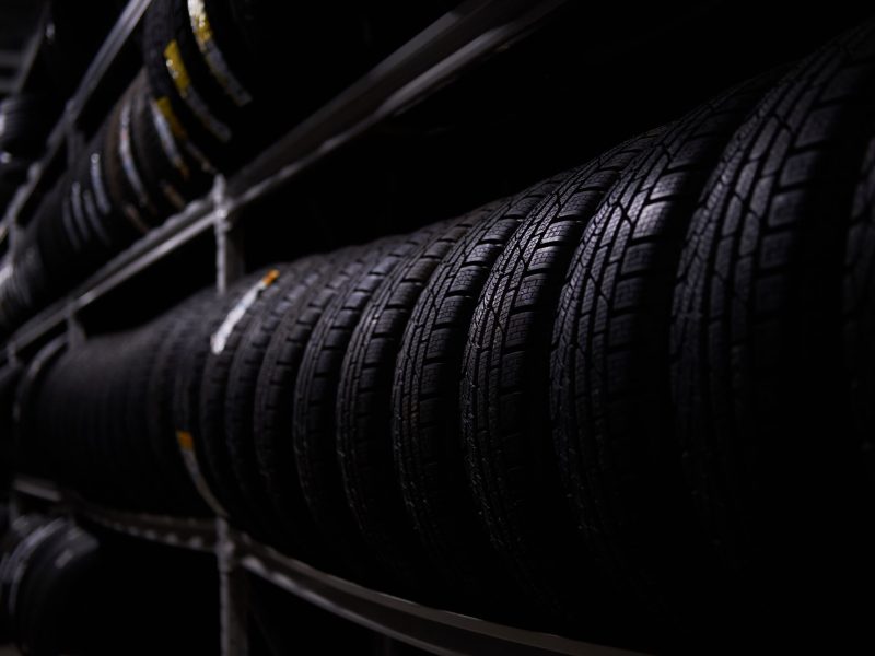 Dark storage full or big variety of new tyres at busy warehouse.